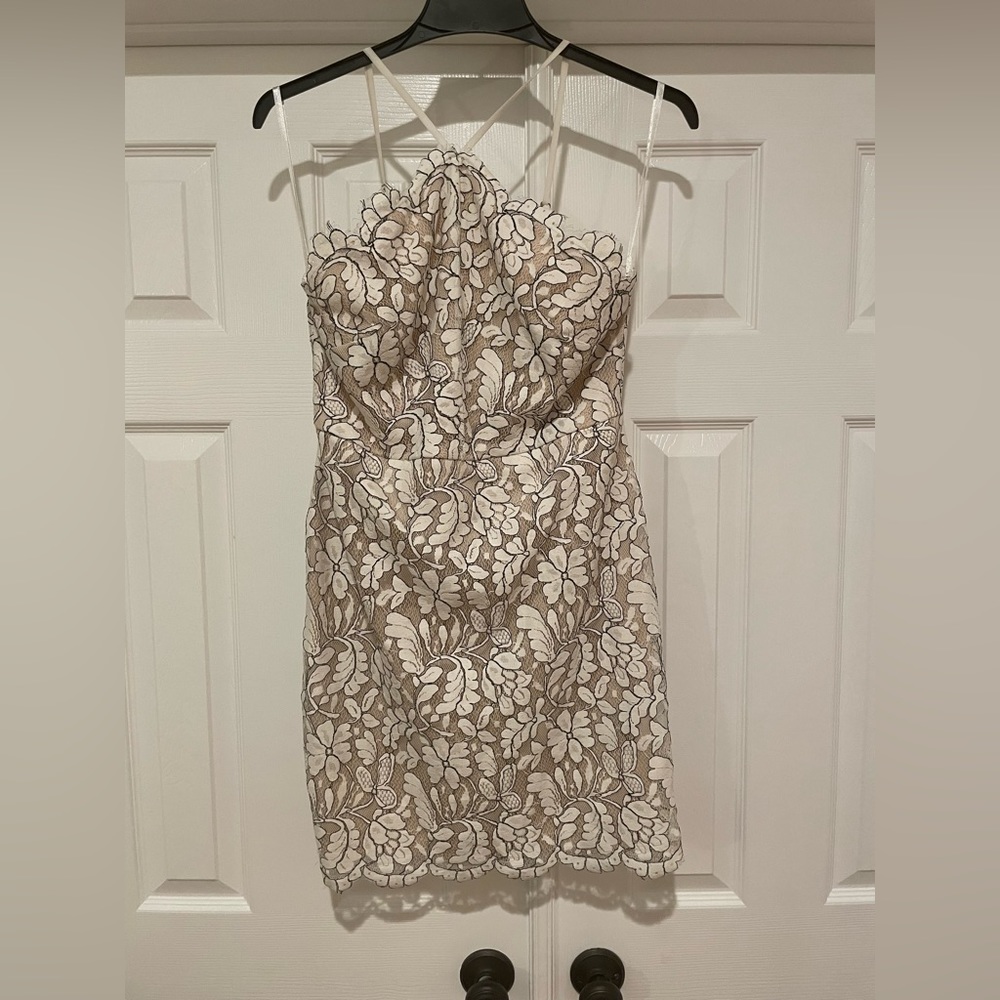 White and black lace halter mini dress with adjustable straps.